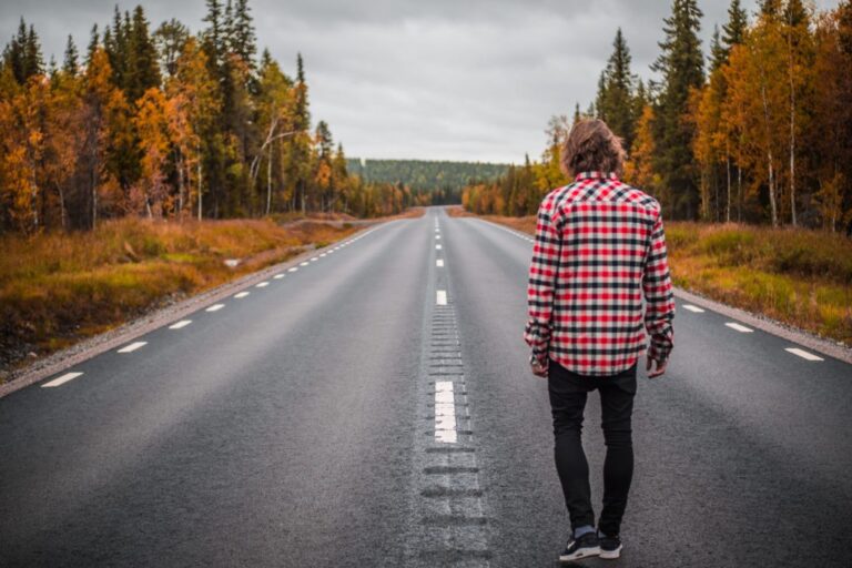 man walking down road in fall