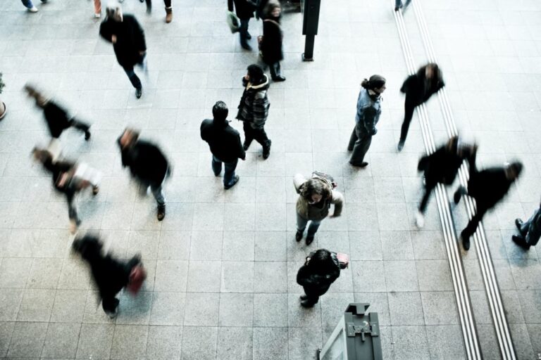 Multiple people at train stop walking quickly to their station